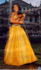 [Vanessa in yellow gown, leaning on a lamp-post, holding acoustic violin]
