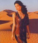 [Vanessa in desert wearing dark brown body-skimming sleeveless dress with flower patterns, sexy]